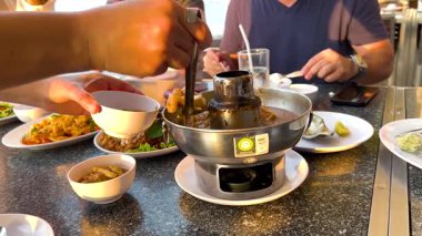 Dostlar deniz kenarında yemek yer.