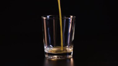 Portakal suyu temiz bir bardağa dökülüyor.