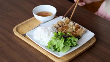 Bahar böreklerini sosa batıran kişi.