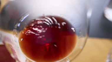 Bardakta dönen kırmızı şarabın yakın çekimi.