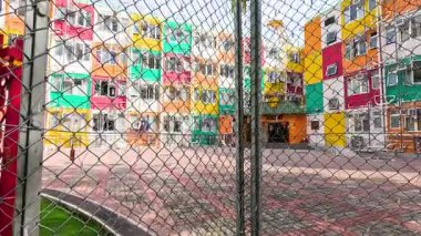 Tel örgülü alandan canlı bir bina görünüyor.