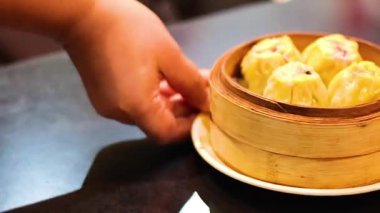 Eller masanın üstünde Siu Mai 'yi sunar.