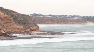 Torquay Sahili 'nde dalgalar kayalık kıyılara vuruyor