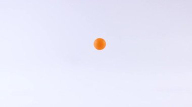 Beyaz bir yüzeyde zıplayan turuncu top.
