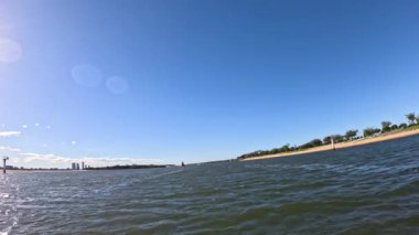 Dalgalar ve açık mavi gökyüzü altında ufuk çizgisi