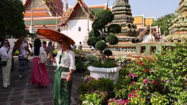 Ziyaretçiler Wat Pho 'nun mimarisine ve bahçelerine hayran