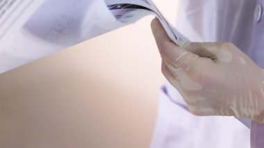 Bilim adamı deney notlarını ve resimlerini inceliyor