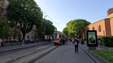 Milano caddesinde insanlar tramvaya biniyor