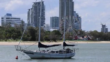 Şehir manzaralı ve dönme dolabı olan bir yelkenli.