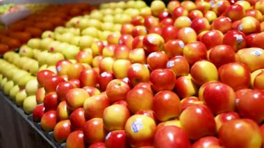 Gold Coast süpermarketinde renkli meyve aranjmanı. Parlak ışıklandırma, düzgün sıralarda elmaları, portakalları ve armutları vurgular