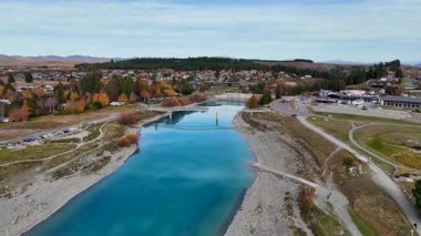 İnsansız hava aracı görüntüleri Tekapo Gölü 'nün canlı sonbahar renklerini ve dingin sularını yakalar ve Good Shepherd Kilisesi' ni ön plana çıkarır.