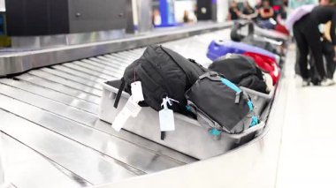 Taşıma bandından çantaları alan yolcular