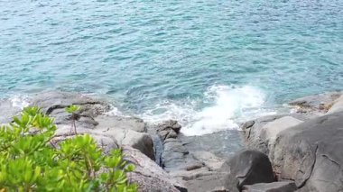 Dalgalar Ao Karon, Phuket, Tayland 'da kayalara çarpıyor.