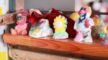 Canlı bir pazarda sergilenen boyalı heykelcikler