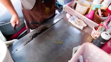 Tedarikçi elektrikli ocakta yengeç çubukları hazırlıyor.