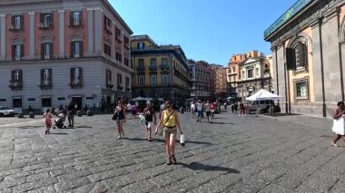 İnsanlar tarihi bir meydanda yürüyor