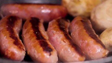 Izgarada pişen sosis ve mantarlar.