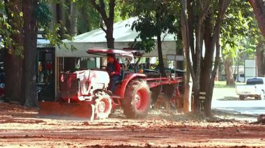 Traktör hayvanat bahçesinde toprakta çalışıyor.