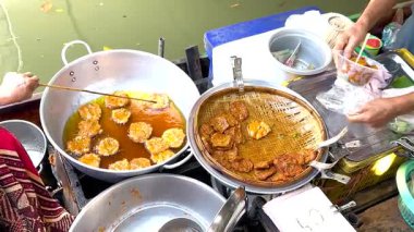 Tedarikçi Bangkok 'ta gevrek midye krepleri hazırlıyor.