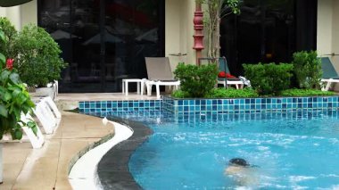 Havuzda yüzen ve su sıçratan bir kadın