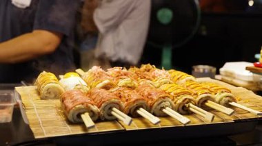 Kızarmış şişler gece pazarında pişiyor.