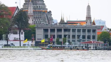 Bir tekne Wat Arun tapınağından geçiyor.
