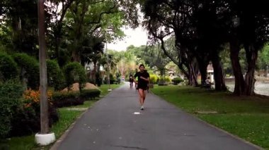 İnsanlar yemyeşil bir parkta koşuyor.