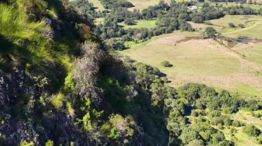 Nimbin, NSW 'deki yemyeşil ve kayalık uçurumların parlak gün ışığı altında havadan görünüşü