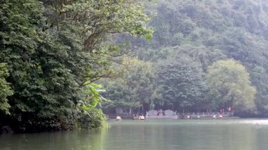 Calm river with lush greenery and distant temple