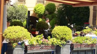 İnsanlar yeşilliklerle çevrili yemeğin tadını çıkarıyorlar.