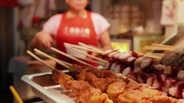 Satıcı yemek standında şiş hazırlıyor.