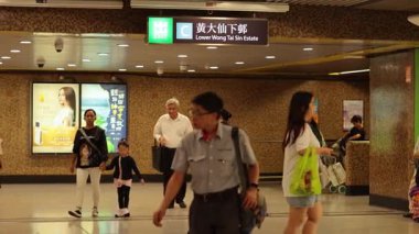 Kalabalık hareketli bir tren istasyonunda ilerliyor.