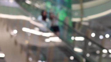 Two friends laughing together while descending an escalator