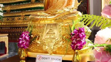 Buddha statue surrounded by flowers and offerings