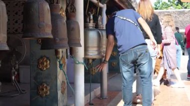 Individuals ringing bells in a temple setting