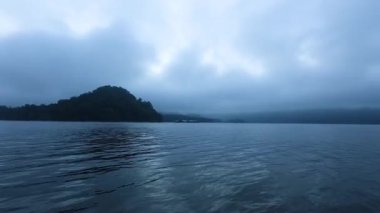 Cloudy sky over tranquil island and lake
