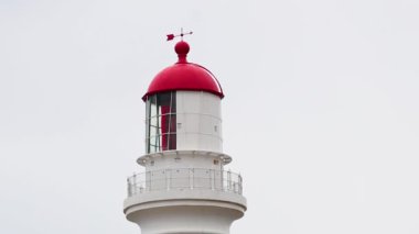 A serene timelapse of Split Point Lighthouse against a cloudy sky, showcasing subtle changes in lighting and perspective