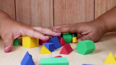 Hands arranging colorful foam blocks on table