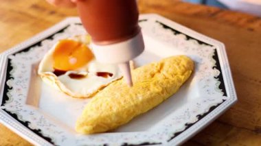 Ketchup being drizzled on an omelette