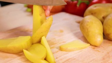 Slicing potatoes with a knife on a board