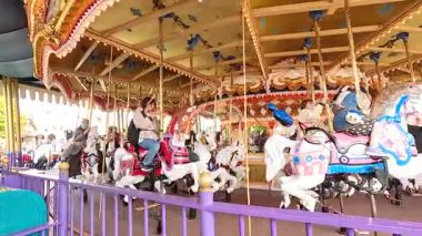 Visitors enjoy a vibrant carousel ride under bright lighting at Tokyo Disneyland, capturing a lively and cheerful atmosphere