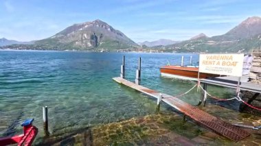 People walking on dock by Lake Como