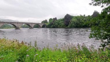 Sakin bir nehir boyunca uzanan taş köprü