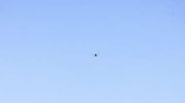 Drone flying in clear blue sky