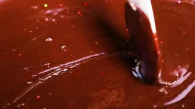 Spoon stirring smooth, rich chocolate mixture