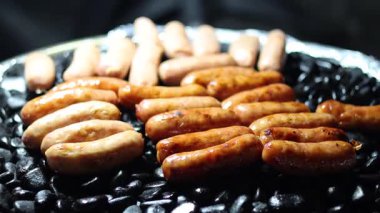 Izgarada eşit derecede pişen cızırdayan sosisler.