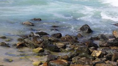 Dinamik okyanus dalgaları kayalara çarpıyor.