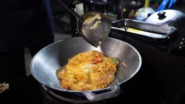 Sokak satıcısı yumurta pişirip servis ediyor.