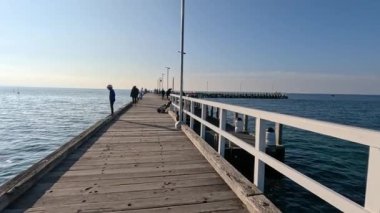 Melbourne 'da bir rıhtımda gezinen turistler