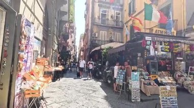 Canlı tezgahları ve turistleri olan kalabalık bir pazar caddesi.